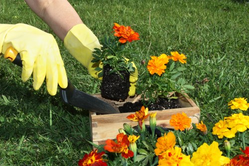 Garden operative wearing PPE while performing maintenance, illustrating staff training and safety