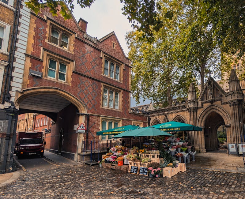 A street scene at the intersection of High Holborn and Grays Inn Road featuring a historic brick building with decorative stonework and arched windows. The building's architecture includes a mix of re